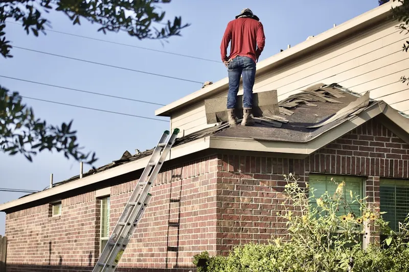 Professional roofer working on a residential roof in Girard